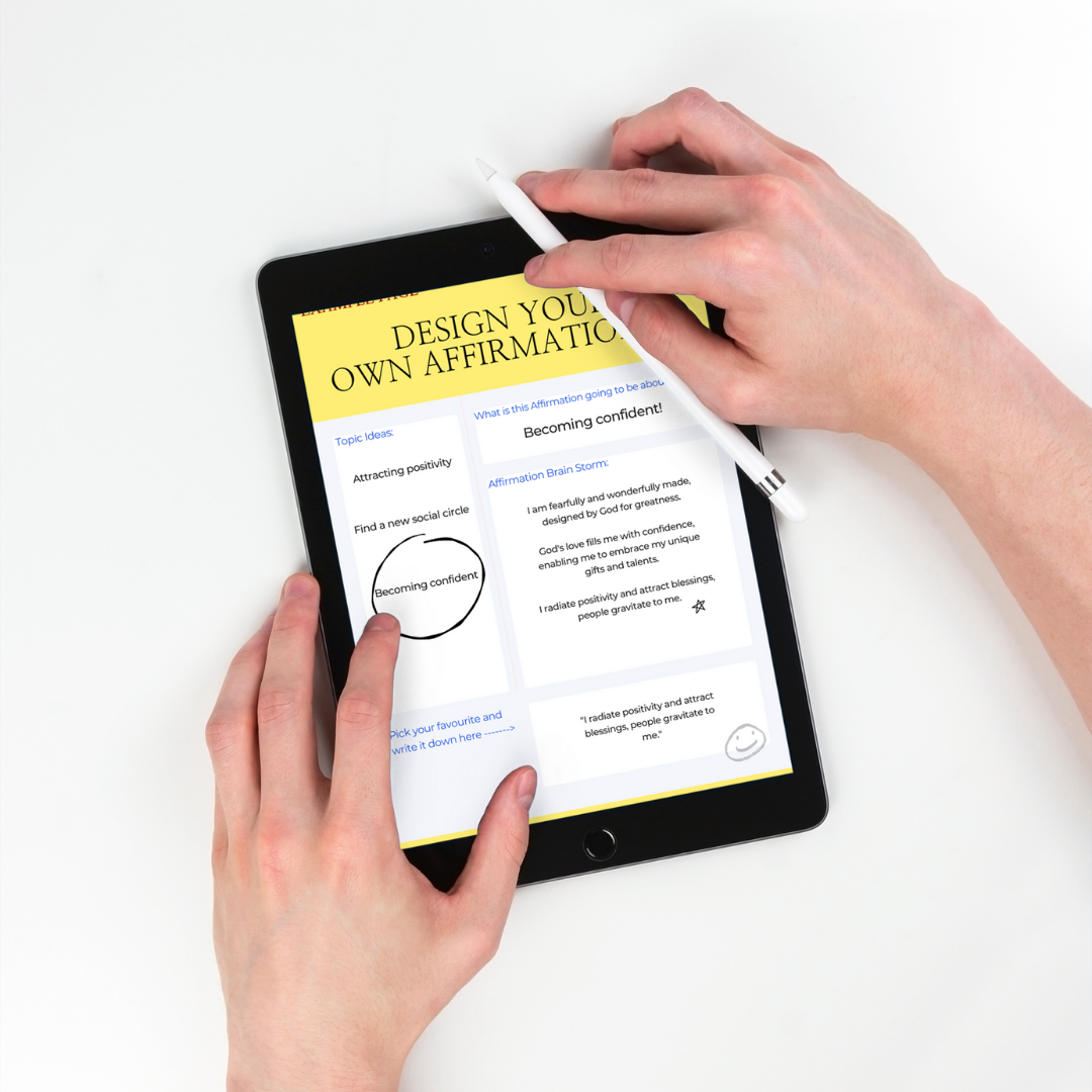 Person using an iPad and pen to interact with 'A Christians Fulfillment Journal - Your Future Planner': Circulating, writing, and drawing on the 'Design Your Own Affirmations' page, promoting hands-on engagement with the journal.